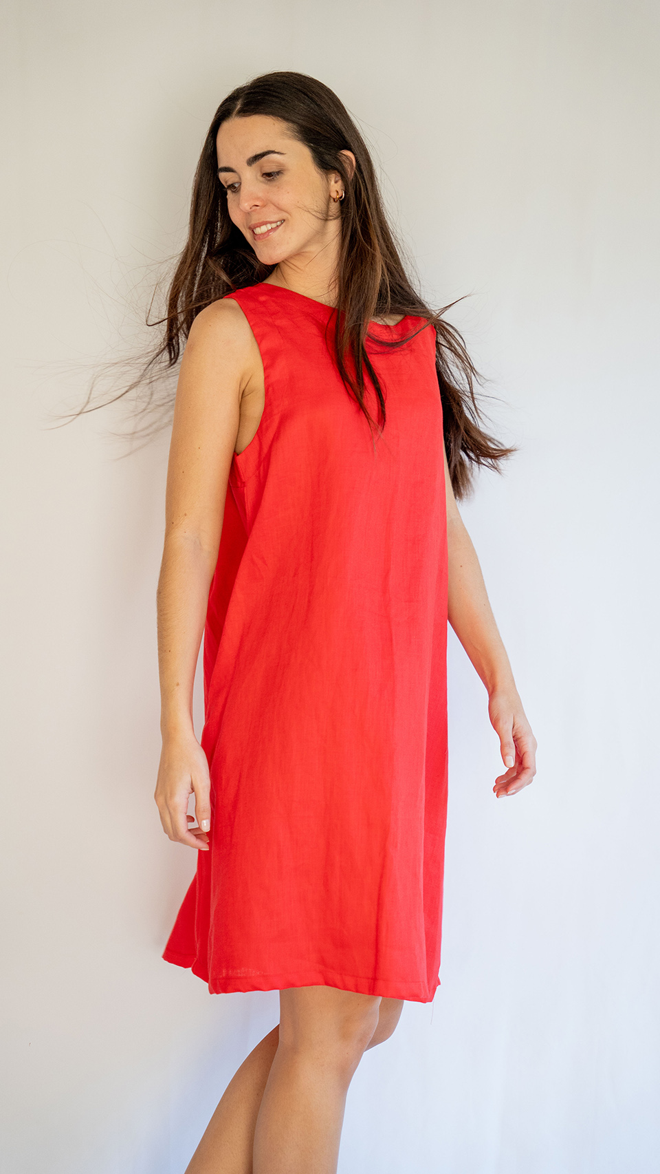 Mujer de costado con vestido de lino rojo de Linen by Delphine